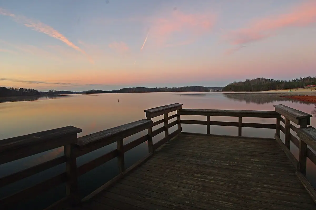 A pier extending into Smith Mountain Lake at sunset.