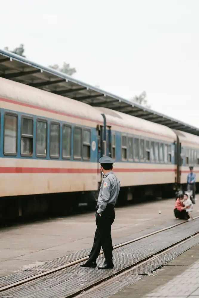 A security guard monitors a train station platform, ensuring passenger safety.