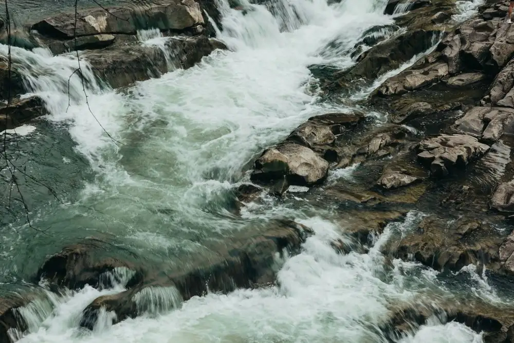 Dynamic river rapids flowing over rugged rocks, showcasing nature's power and beauty.