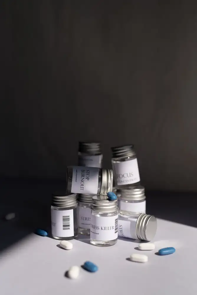 Various medicine bottles and pills arranged artfully on a white background.