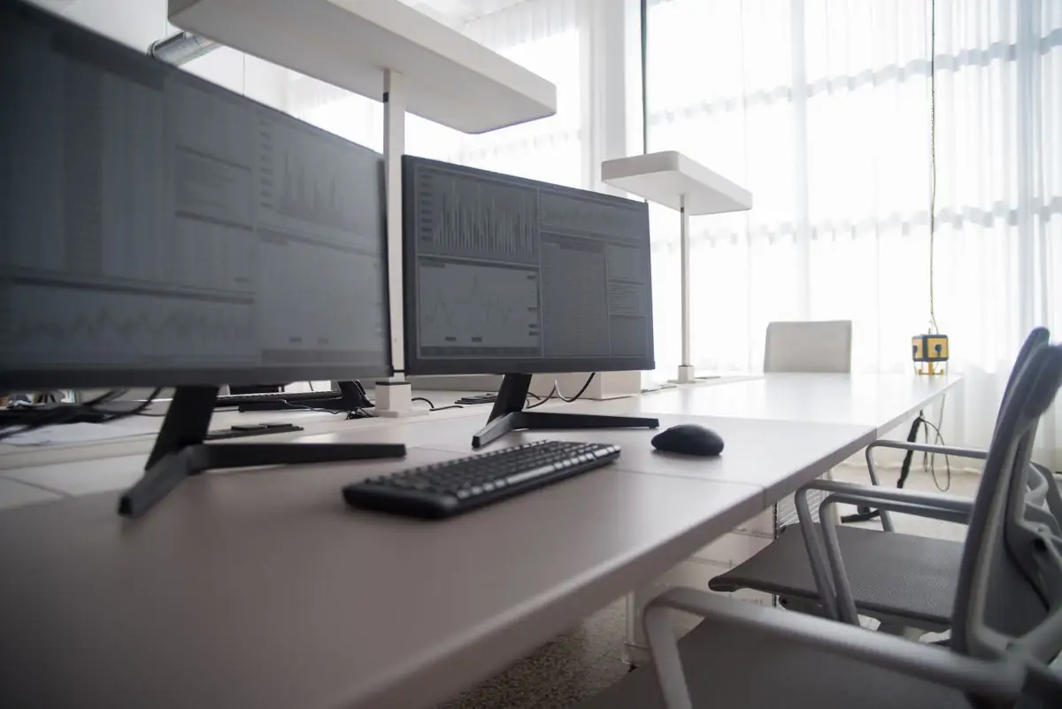 Stylish contemporary office featuring multiple computer monitors and ergonomic chairs.